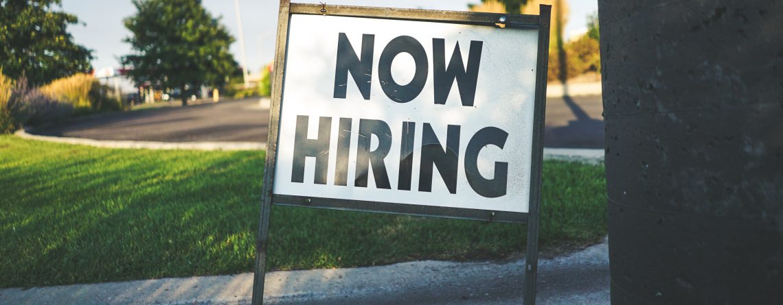 job advert now hiring sign on grass verge