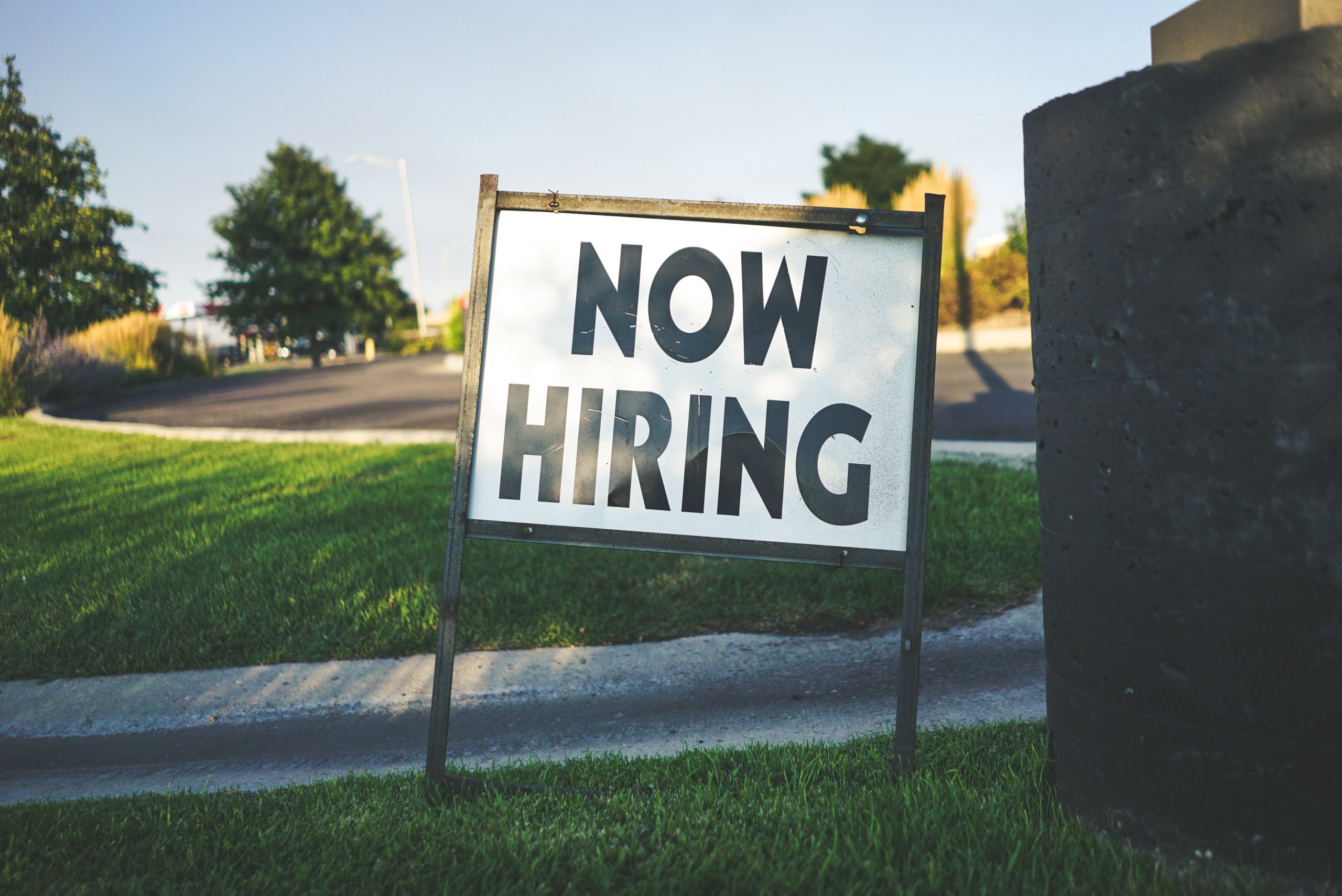 job advert now hiring sign on grass verge