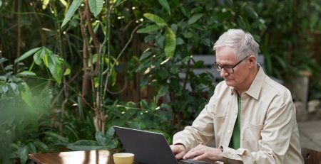 Man at his laptop outside in a garden